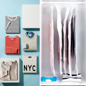 Hanging vacuum storage bags for clothes organized in a white wardrobe closet.
