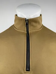 Detailopname van een kaki sweatshirt met opstaande kraag en metalen ritssluiting