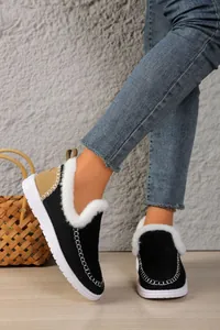 Close-up of warm black snow boots with white faux fur lining and stitching details.