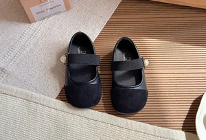Close-up of black French-style Mary Jane shoes with pearl accent and soft sole