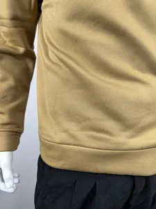 Detailopname van de warme kaki sweatshirt-stoftextuur en geribbelde zoom van het shirt