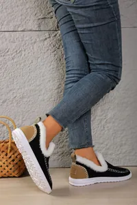 Detailed view of women's black winter snow boots with white faux fur lining and flat sole.