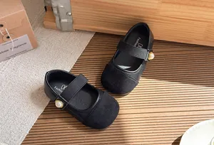 Detail view of black Mary Jane shoes for girls with pearl embellishment