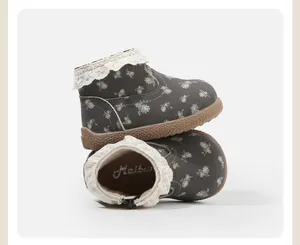 Detail von geblümten Kleinkinderschuhen mit Spitzenbesatz und weicher Gummisohle