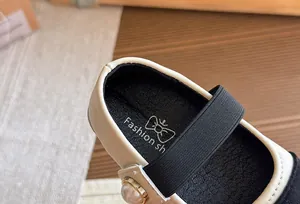 Close-up of girls' Mary Jane shoe showing the insole logo and pearl strap detail.