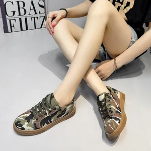 Women's camouflage low-top canvas flats shown in a casual lifestyle studio setting