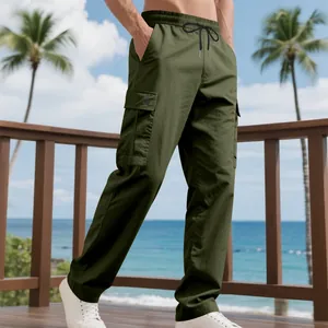 Olivegrüne Herren-Cargo-Hose mit Kordelzug und Taschen vor Strandhintergrund.