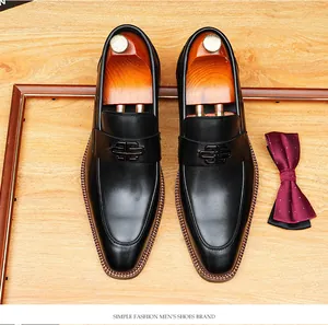 Top view of black leather loafers with a stylish metal buckle and wooden shoe trees