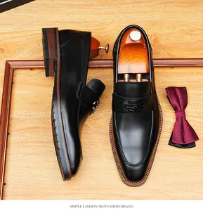 Detailed view of men's black genuine leather loafers with elegant metal buckle detail.