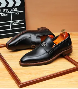 Close-up detail of premium black leather men's loafers featuring an elegant metal buckle