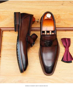 Detailed view of brown leather loafers with a classic metal buckle and gradient finish