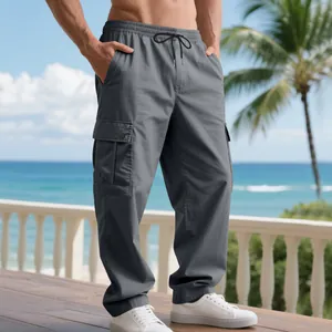 Seitenansicht der grauen Herren-Cargohose mit mehreren Taschen in Strandumgebung.