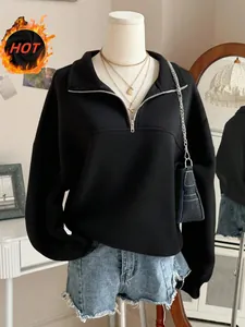 Detailansicht eines schwarzen Oversize-Sweatshirts mit halbem Reißverschluss und Kragen