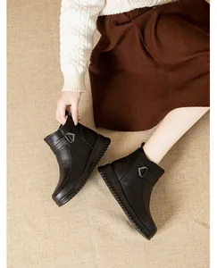 Detailed view of black women's ankle boots featuring a rhinestone buckle and thick sole