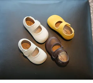 Detaillierte Nahaufnahme von Lauflernschuhen für Mädchen in den Farben Weiß, Gelb und Braun.