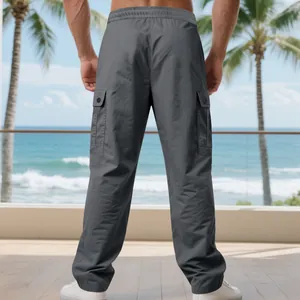 Rückansicht von grauen Cargo-Hosen für Herren mit Seitentaschen am Strand im Detail.
