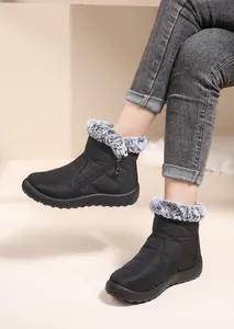 Close-up of black waterproof snow boots with fluffy fur collar for women