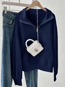 Close-up detail of a classic navy blue half-zip sweatshirt featuring a stylish collar design