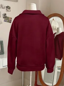 Detailed back view of a maroon solid color half-zip collar sweatshirt displayed on a mannequin