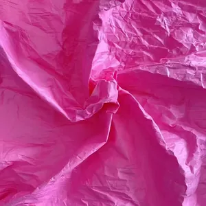 Detailed texture of bright pink crinkled paper for DIY floral and wedding crafts.