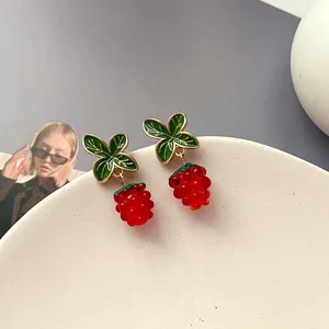 Detail von Vintage-Beeren-Ohrringen mit roten Glaskugeln und grünen Emaille-Blättern