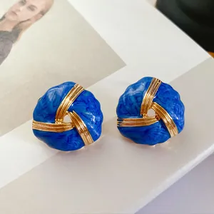 Detailed view of vintage blue enamel stud earrings with twisted gold-tone accents and 925 silver needles