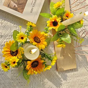 Top-down view of artificial sunflower candle rings on a wooden surface with warm sunlight