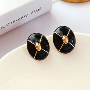 Detailed macro shot of vintage black enamel stud earrings with elegant gold accents