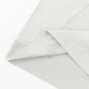 Macro view of premium white linen fabric and neat hem stitching on a men's casual shirt.