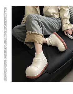 Nahaufnahme eines Mädchens mit warmen, dicken, weißen Winter-Baumwollschuhen auf Sofa