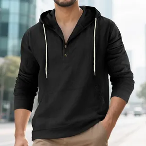 Detailed view of black linen hooded Henley shirt with buttons and kangaroo pocket.