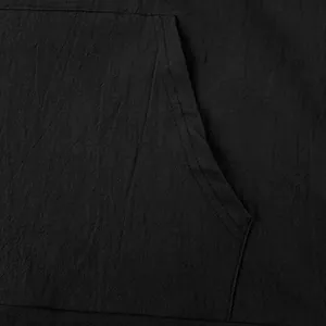 Close-up of the reinforced pocket stitching on black linen-textured men's hooded shirt