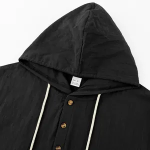 Detail shot of black linen hooded Henley shirt with visible fabric texture and wood buttons.