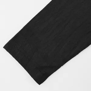 Close-up of the breathable black linen fabric texture on a casual men's Henley shirt.