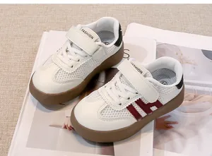 Detailansicht weißer Kinder-Sneaker mit burgunderfarbenem H-Riemen und Gummisohle.