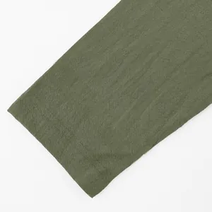 Close-up detail of olive green linen fabric texture on men's long sleeve shirt