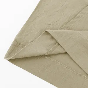 Close-up of khaki linen fabric texture and hem stitching on a men's casual shirt