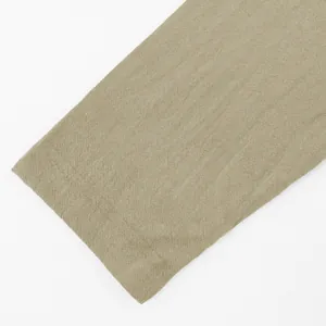 Detailed macro shot of khaki linen fabric texture and stitching on shirt sleeve