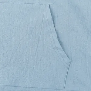 Macro detail of the reinforced front pocket on a light blue linen textured casual hoodie shirt