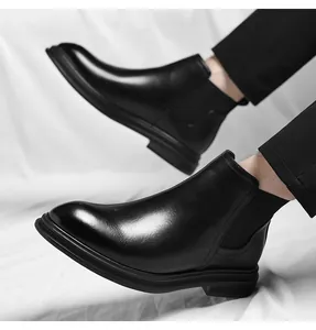 Detailed view of polished black leather Chelsea boots for men with elastic side panels.