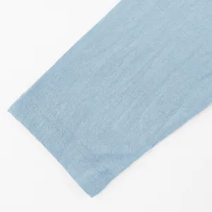 Close-up of light blue linen fabric texture showing details of long sleeve Henley shirt