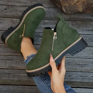 Détail de bottines en daim vert olive avec fermeture éclair et semelle épaisse