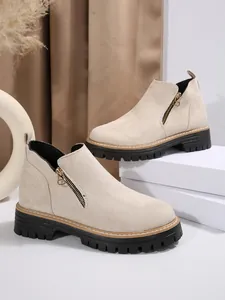 Vue détaillée des bottines Martin en daim beige avec semelle crantée noire et fermeture éclair