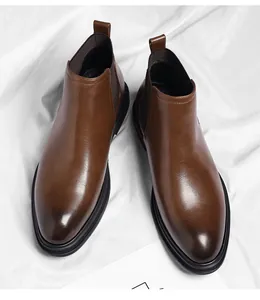 Top-down detail view of premium brown leather Chelsea boots for men on white textured background