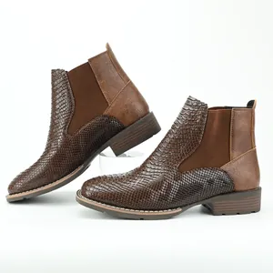 Detail of brown Chelsea boots with contrasting smooth and snakeskin leather textures.