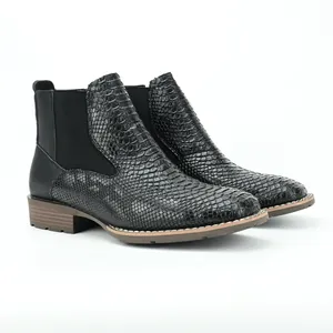 Detailed side view of black men's Chelsea boots with snakeskin texture and elastic panels