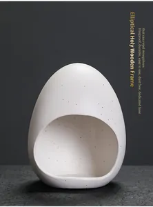 Close-up van witte keramische wierookbrander in eierschaalvorm met gespikkelde textuur