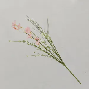 Künstliche rosa Blumen auf grünen Zweigen für elegante Tischdekoration zu Hause