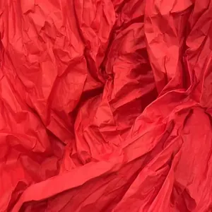 Detailed macro texture of red crumpled crepe paper for DIY floral and wedding crafts