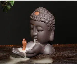 Detail van een zen Boeddha hoofd backflow wierookbrander met stromende rook en kleine monnik